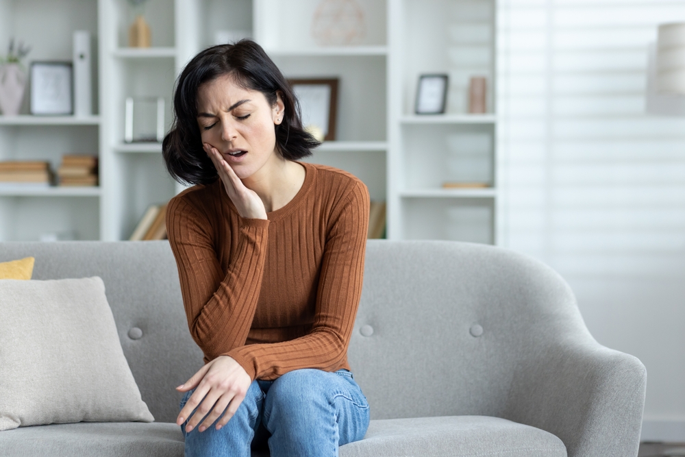 A,Sick,Young,Woman,Sits,At,Home,On,The,Sofa