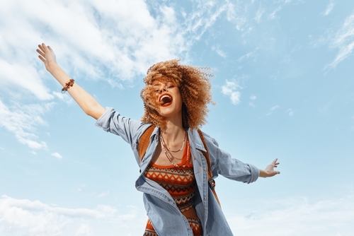 Smiling,Young,Woman,With,Curly,Hair,Enjoying,A,Carefree,Beach